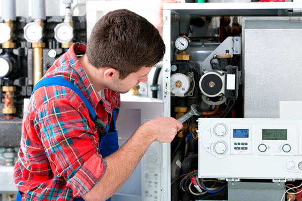 Heating technician repairing boiler controls in Port Hueneme