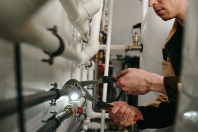Technician inspecting commercial plumbing pipes in Port Hueneme