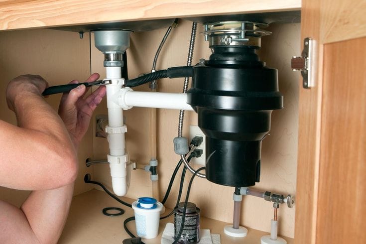 Plumber repairing a garbage disposal in Port Hueneme